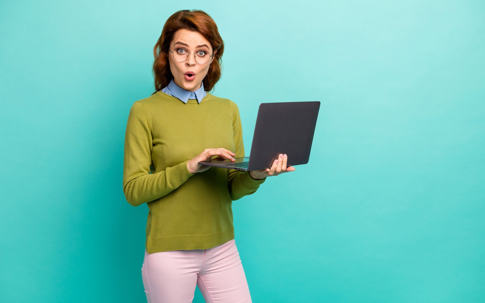Surprised woman using a laptop to compare free website making sites