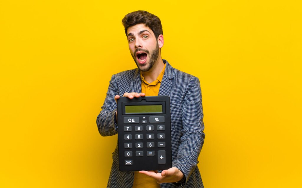 Man holding a large calculator, reacting to how much a website costs
